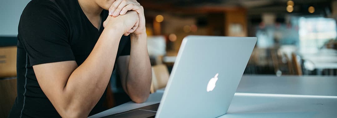 Online-Therapie Ein Mann sitzt vor einem Laptop