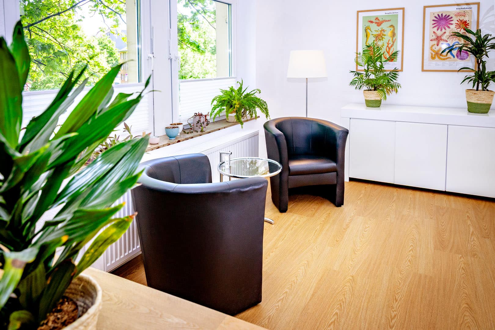 Behandlungsraum Zwei schwarze Ledersessel in einem hellen Behandlungsraum